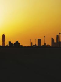 Silhouette buildings against clear sky during sunset