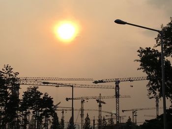 Silhouette of crane against sky during sunset