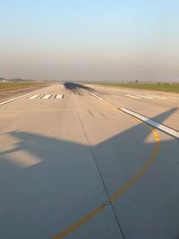 Airplane on runway against clear sky