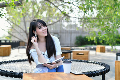 Young woman sitting on table