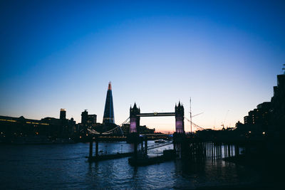 View of suspension bridge over river against blue sky