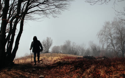 Rear view of woman walking on snow covered landscape