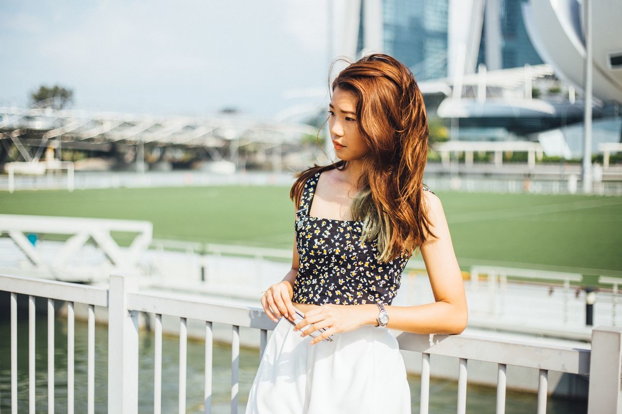 young adult, young women, lifestyles, person, long hair, standing, casual clothing, focus on foreground, leisure activity, three quarter length, waist up, railing, medium-length hair, side view, looking away, blond hair, brown hair