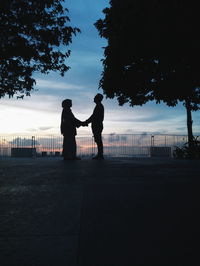 Silhouette couple standing against sky