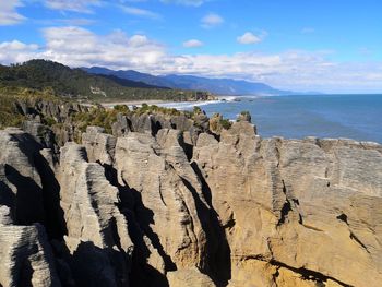Panoramic view of rocks formations in sea against sky