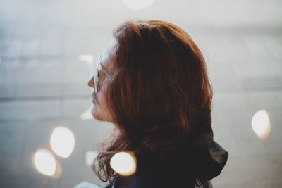 Portrait of woman looking at illuminated camera