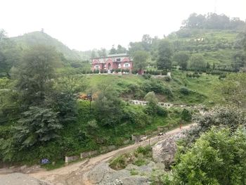 Scenic view of trees and houses against sky