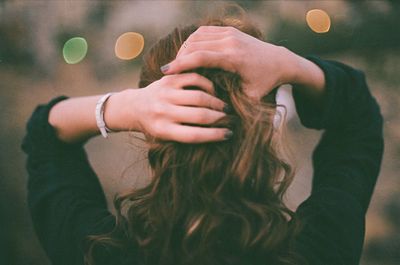 Rear view of woman with hand in hair