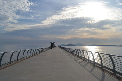 Pier over sea against cloudy sky