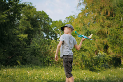 Caucasian boy launching toy plane in park