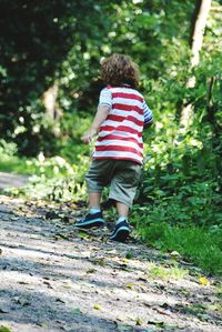 Low angle view of boy running along footpath