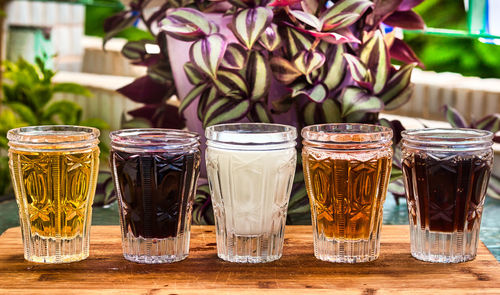 Five crystal glasses with colorful drinks. close-up of drink on table