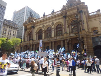 People in town square against sky in city