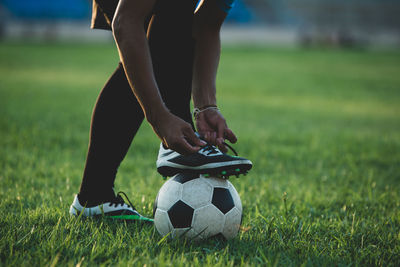 Low section of person relaxing on field