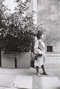 Full length of woman walking by plants