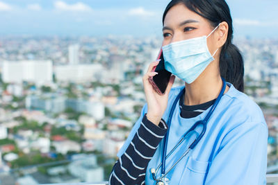 Portrait of young woman standing in city