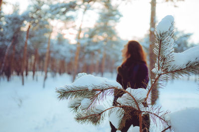 Rear view of woman standing on snow