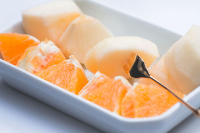 Close-up of fresh orange and muskmelon in plate