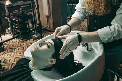 Midsection of man washing hands in sink