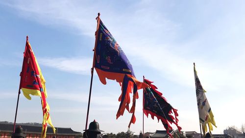 Low angle view of flags hanging against sky