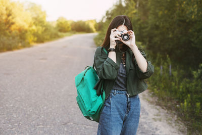 Cute brunette looks at the camera lens. the girl travels and takes photos of landscapes 