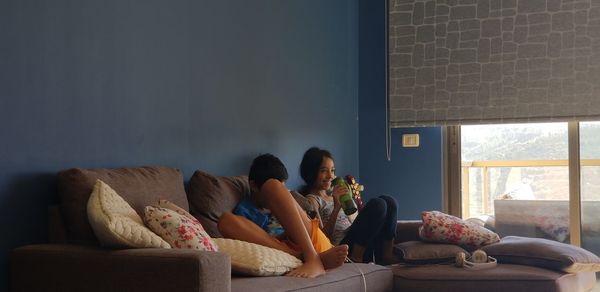 Woman sitting on sofa at home