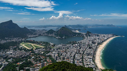 High angle view of city by sea against sky