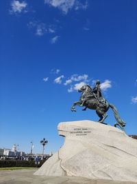 Low angle view of statue against blue sky