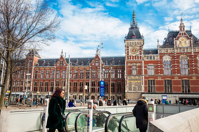 People in front of buildings against sky