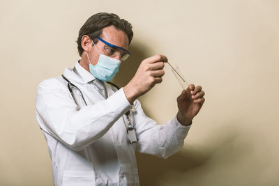 Doctor wearing mask against colored background