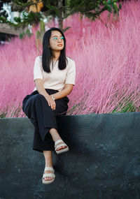 Portrait of young woman sitting on field