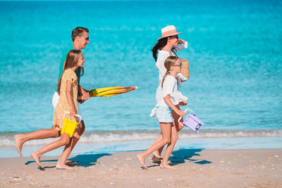 Full length of friends enjoying at beach