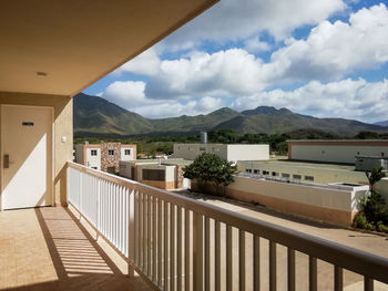 Built structure by houses and mountains against sky