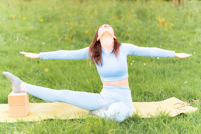 Full length of woman with arms raised on field