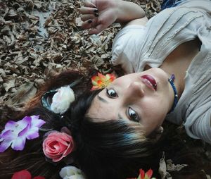 High angle portrait of woman lying down on field