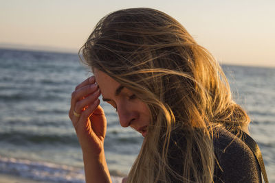 Close-up of woman at beach against sky