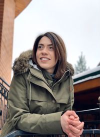 Portrait of smiling young woman standing in snow