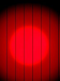 Lit spot on red wooden wall