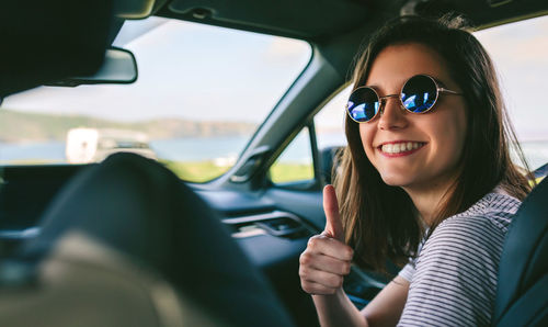 Portrait of a smiling young woman in car