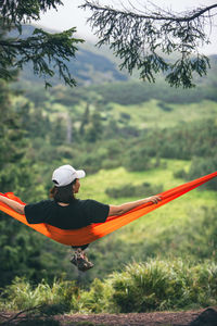 Rear view of woman with arms outstretched on mountain