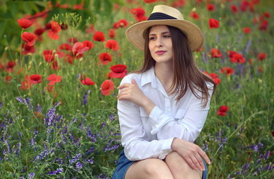 Beautiful young woman with pink flowers in garden