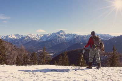 Woman on snowcapped mountain against sky