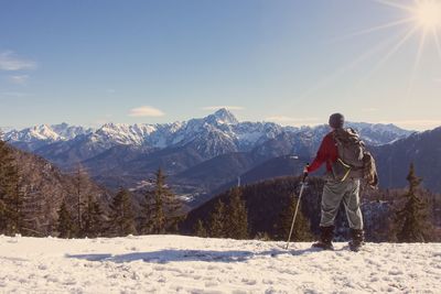 Woman on snowcapped mountain against sky