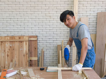 Portrait of smiling man standing against wall at home