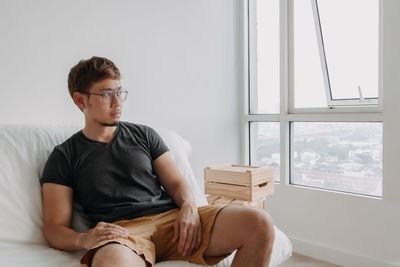 Side view of young man using laptop at home