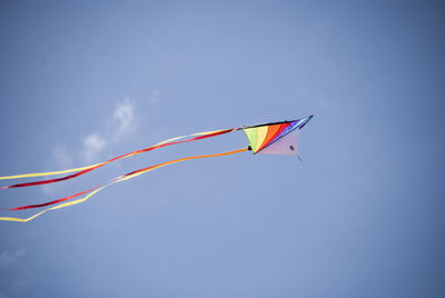 Low angle view of colorful kite flying in sky