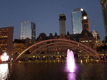 Illuminated buildings against sky at night