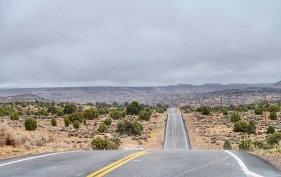 Road leading towards mountain against sky