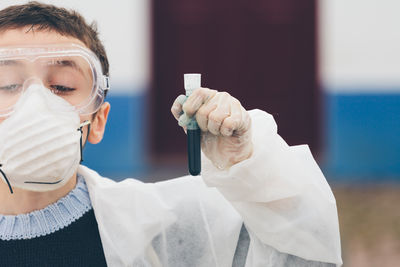 Cropped image of boy holding test tube in laboratory during science project