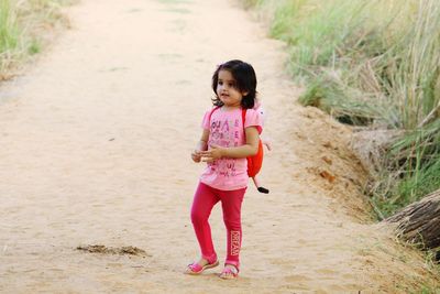 Full length portrait of happy girl standing on beach